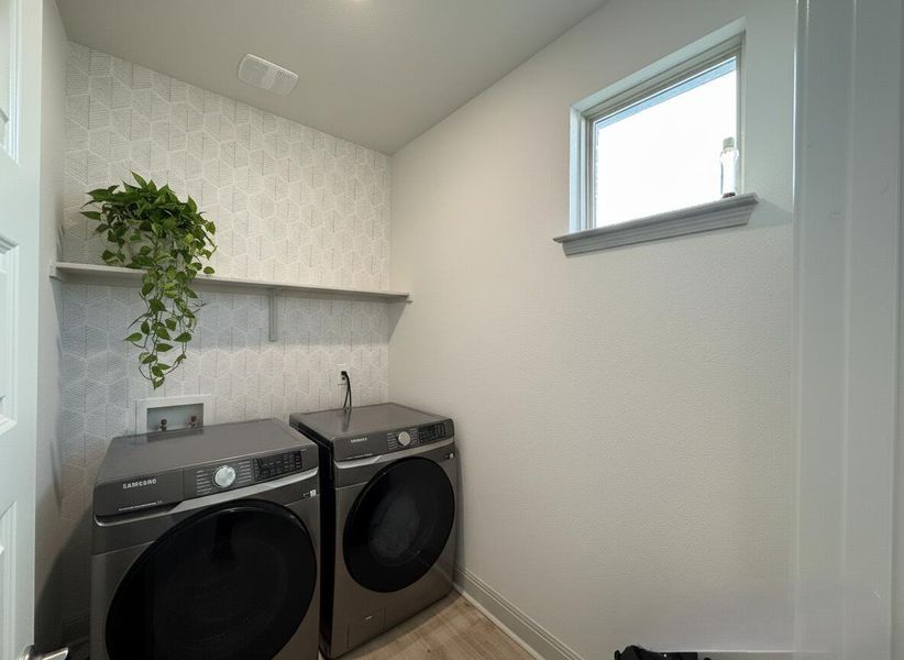 Laundry room with washer and dryer and baseboards