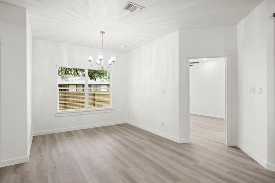 A well-lit dining area offers wood flooring and a classic chandelier. A well-lit dining area offers wood flooring and a classic chandelier.