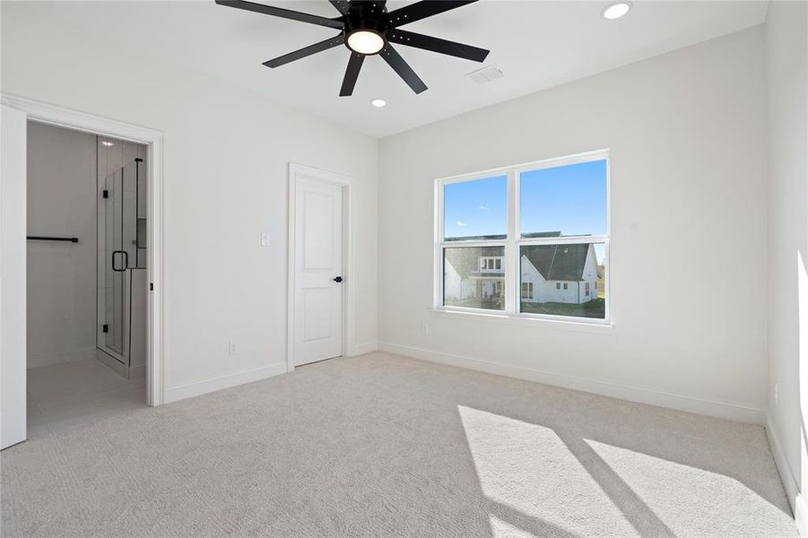 Carpeted spare room featuring ceiling fan