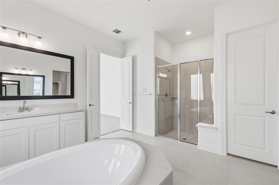 Bathroom with vanity, a shower stall, light tile patterned floors, and a bath Bathroom with vanity, a shower stall, light tile patterned floors, and a bath