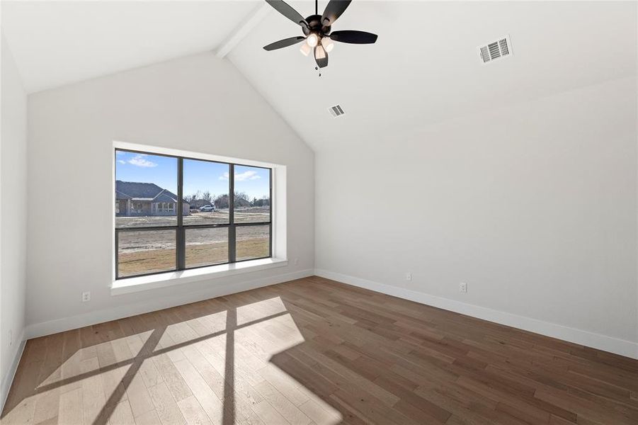 Unfurnished room featuring beam ceiling, hardwood / wood-style flooring, high vaulted ceiling, and ceiling fan