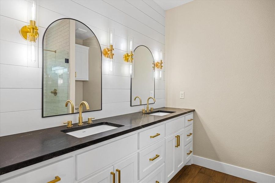 Full bath featuring double vanity, dark wood-style floors, and tiled shower Full bath featuring double vanity, dark wood-style floors, and tiled shower