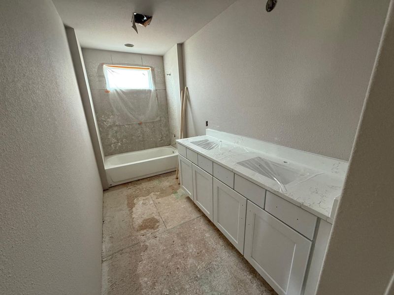 Full bath with a textured wall and vanity Full bath with a textured wall and vanity
