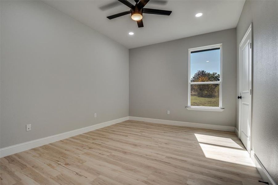 Unfurnished bedroom featuring light wood finished floors, ceiling fan, recessed lighting, and a baseboard heating unit Unfurnished bedroom featuring light wood finished floors, ceiling fan, recessed lighting, and a baseboard heating unit