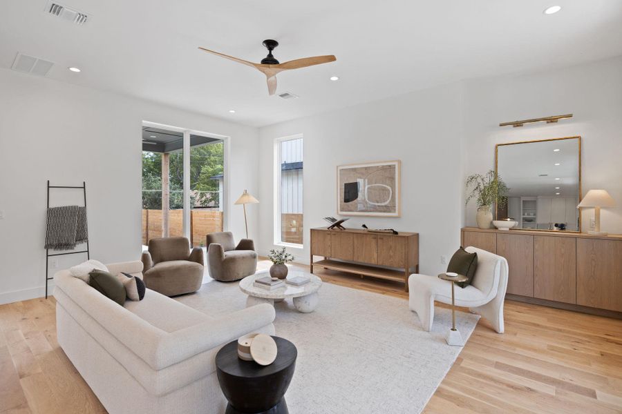 Living room featuring recessed lighting, ceiling fan, and light wood-style floors Living room featuring recessed lighting, ceiling fan, and light wood-style floors