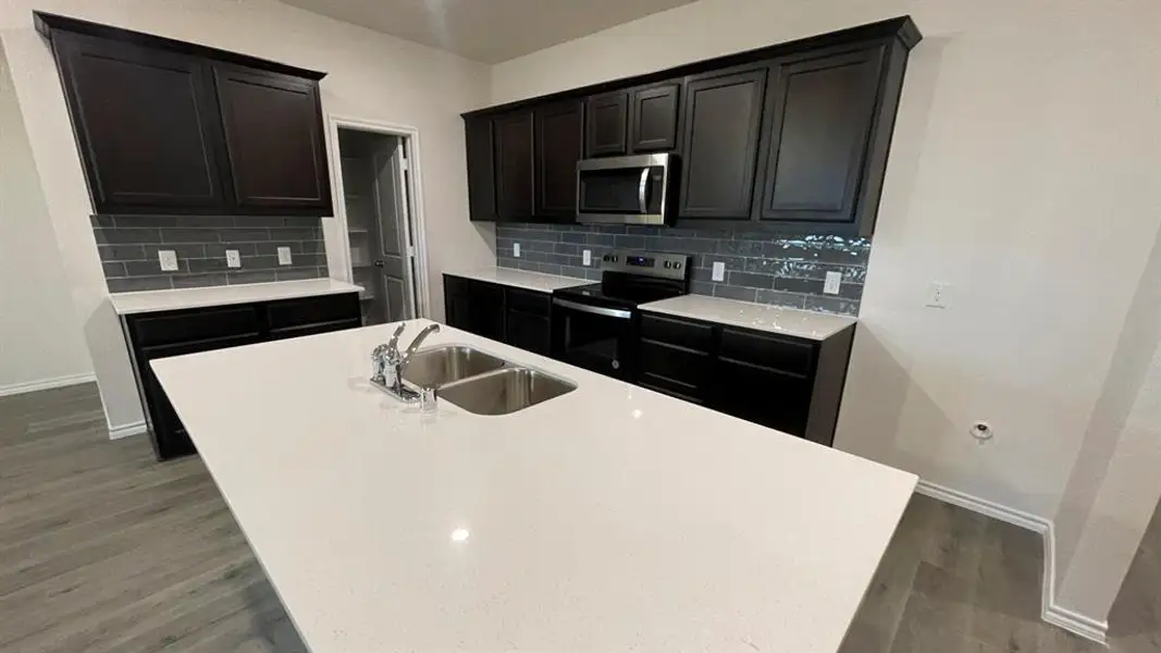 Kitchen island with a double basin sink and a chrome faucet