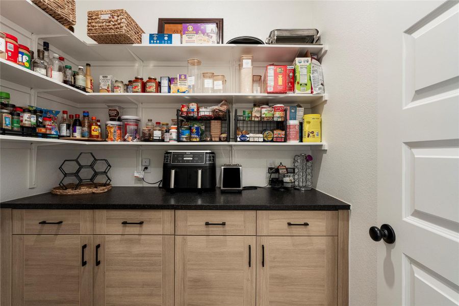 A well-organized pantry offers ample storage with open shelving and countertop space. A well-organized pantry offers ample storage with open shelving and countertop space.