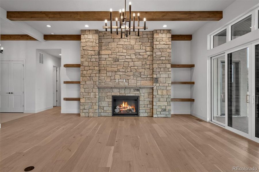 A 48-inch limestone-surround gas fireplace anchors the great room, complemented by floating wood shelves.