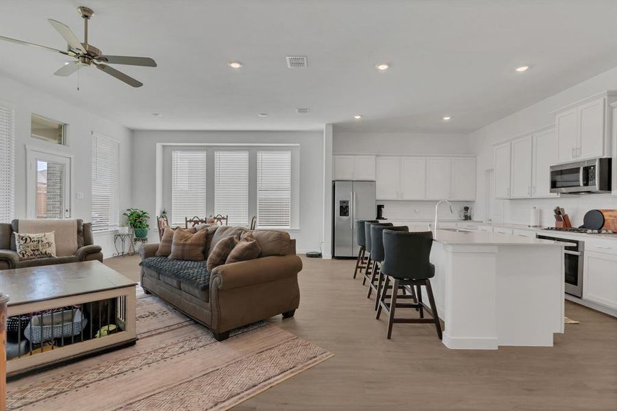 Living room featuring recessed lighting, light wood-style floors, healthy amount of natural light, and a ceiling fan