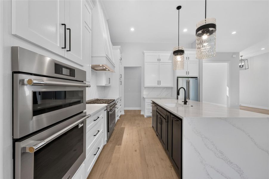 Gleaming stone countertops and premium appliances anchor this expansive, modern kitchen design.
