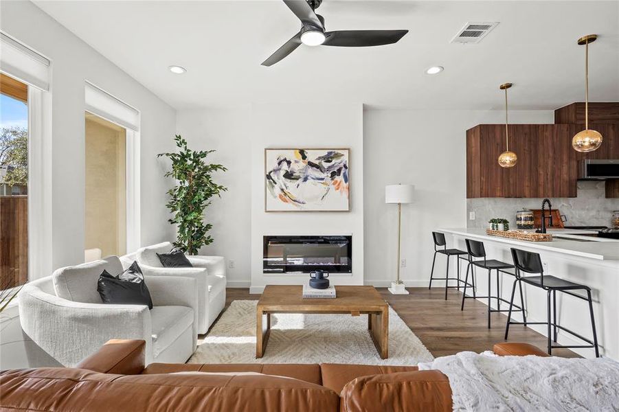 Living room featuring ceiling fan, wood-type flooring, and sink