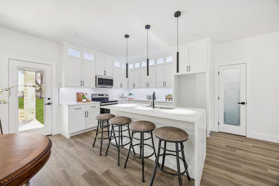 Kitchen featuring a kitchen breakfast bar, a kitchen island with pendant lighting