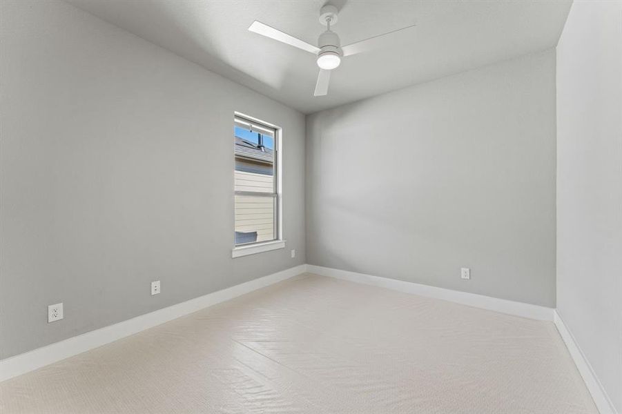 Spare room with light carpet, ceiling fan, and a skylight