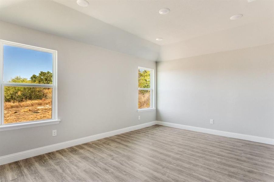 Unfurnished room with wood finished floors and recessed lighting
