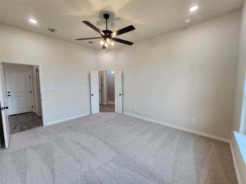 Expansive room featuring vaulted ceilings, a ceiling fan with integrated lighting, recessed lighting, and soft neutral carpet flooring