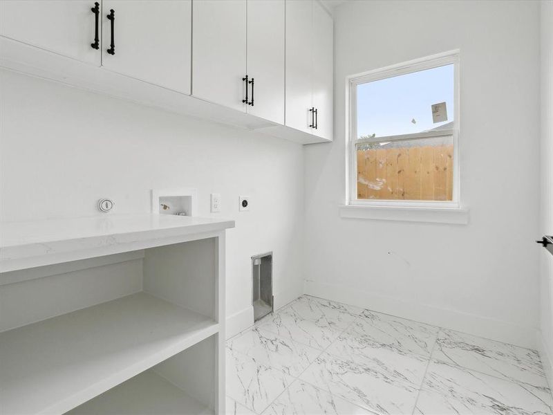 Washroom featuring hookup for a washing machine, cabinets, and hookup for an electric dryer