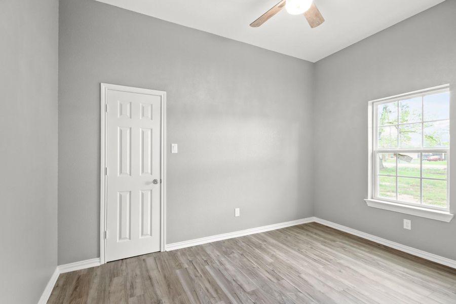 The 3rd bedroom features a large window and ceiling fan.