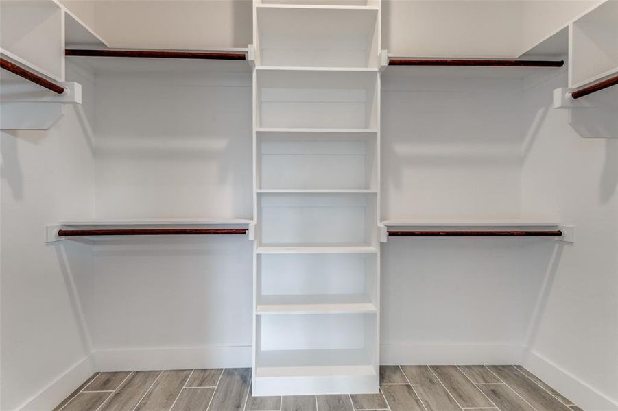 Spacious closet with light hardwood / wood-style flooring