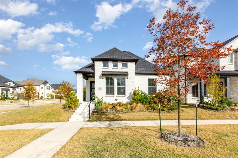 View of front of house with a front yard, brick siding, roof with shingles, and a residential view View of front of house with a front yard, brick siding, roof with shingles, and a residential view