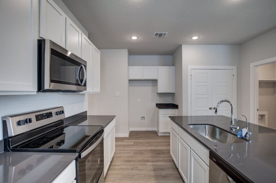A kitchen with white cabinets.
