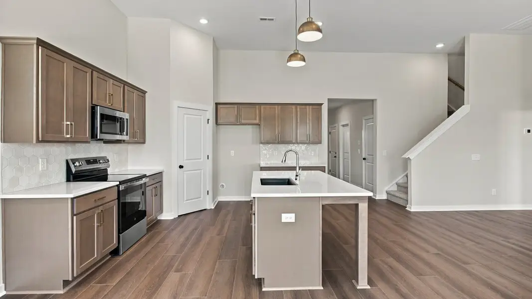 Kitchen with ceramic tile backsplash, quartz countertops, and stainless steel appliances Kitchen with ceramic tile backsplash, quartz countertops, and stainless steel appliances