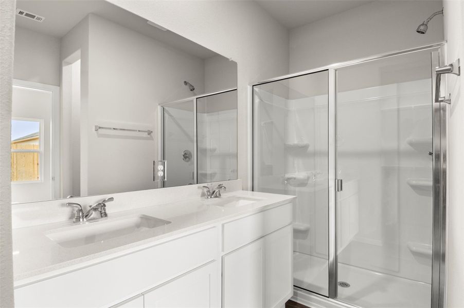Bathroom featuring a shower stall and a sink