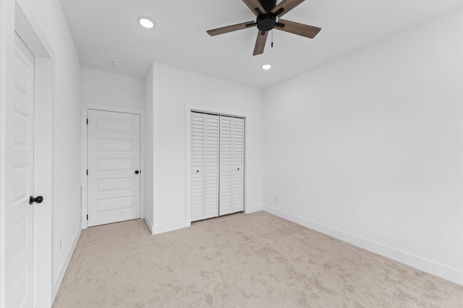 Bedroom 2 includes a door (on the left in this photo) that leads to a Hollywood bath with a dual sink vanity.