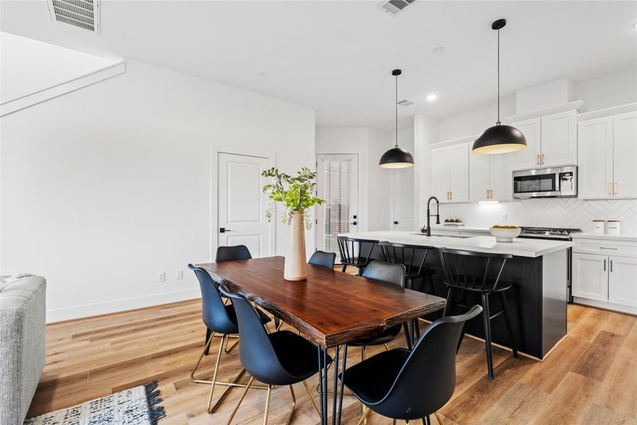 The spacious dining area, adjacent to a chef’s kitchen with a large island, provides the perfect setting for hosting family and friends in style.