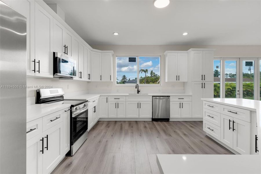 CUSTOM KITCHEN W/ CENTER ISLAND OVERLOOKING THE OPEN FLOOR PLAN LIVING ROOM.