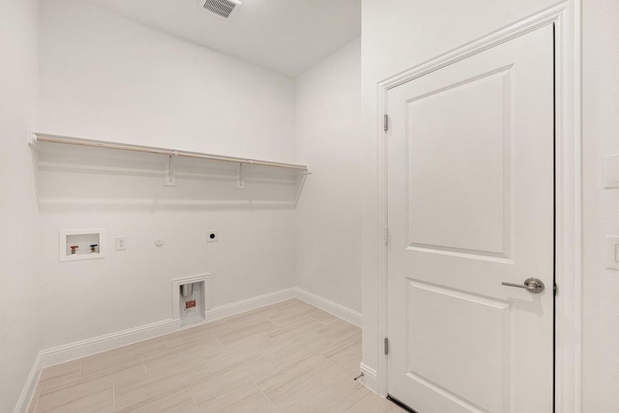 Laundry room with wall shelf, washer hookups, gas dryer connection, and light tile floors