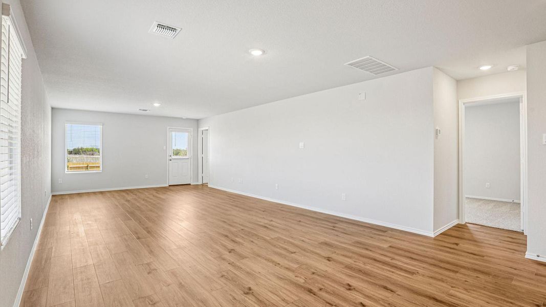 Spacious interior featuring wood-finish flooring, recessed lighting, and bright white walls Spacious interior featuring wood-finish flooring, recessed lighting, and bright white walls