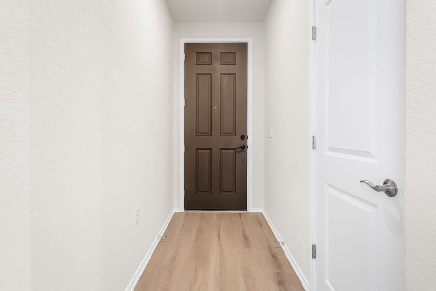 A welcoming entryway with a rich wood paneled door opens to durable wood flooring, inviting you further inside. A welcoming entryway with a rich wood paneled door opens to durable wood flooring, inviting you further inside.