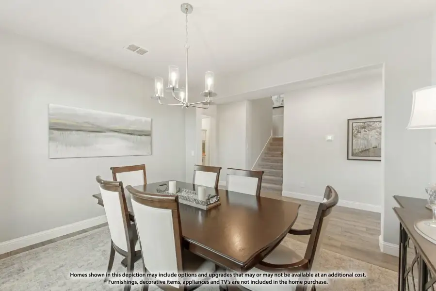 Dining room with dark wood table, six chairs, chandelier, and hardwood floors near staircase