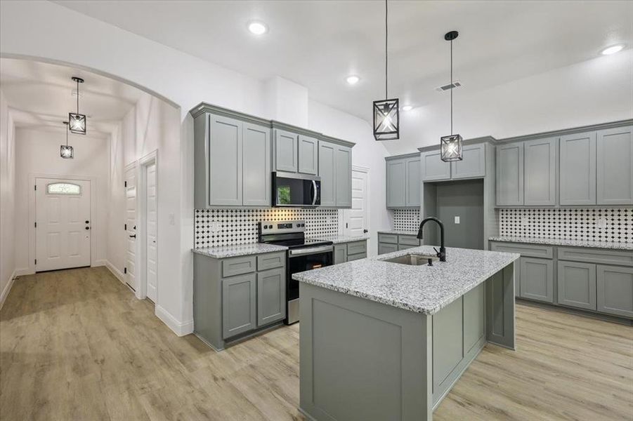 Kitchen with gray cabinets, backsplash, stainless steel appliances, and recessed lighting Kitchen with gray cabinets, backsplash, stainless steel appliances, and recessed lighting