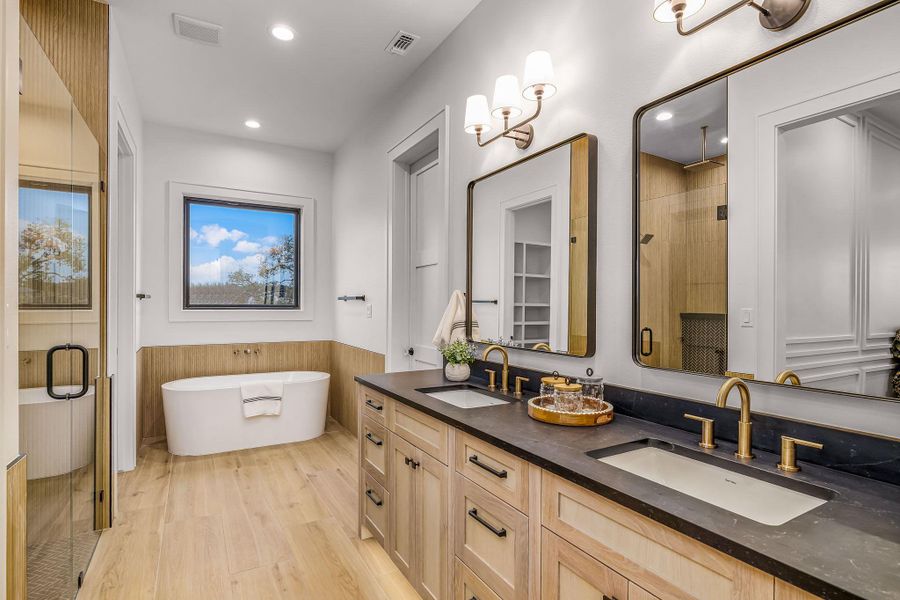 Bathroom featuring wood finished floors, a stall shower, a soaking tub, and a sink