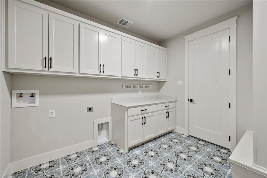 Laundry room with plenty of cabinets and  a mud bench!