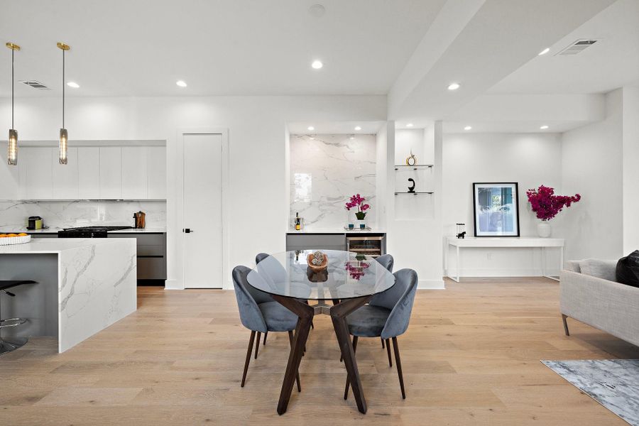 The elegant dining area is designed for both everyday meals and entertaining. A stylish dry bar adds functionality and charm, perfect for serving drinks or showcasing decorative accents. Thoughtfully placed lighting and an accent wall enhance the space, creating a warm and inviting atmosphere for gatherings and special occasions.