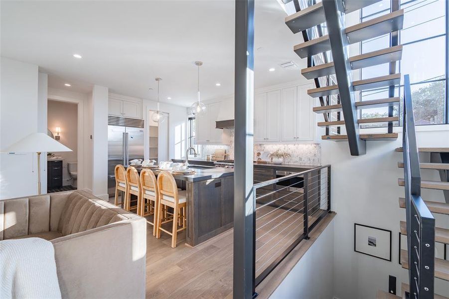 Stairway with hardwood / wood-style flooring, beverage cooler, and sink