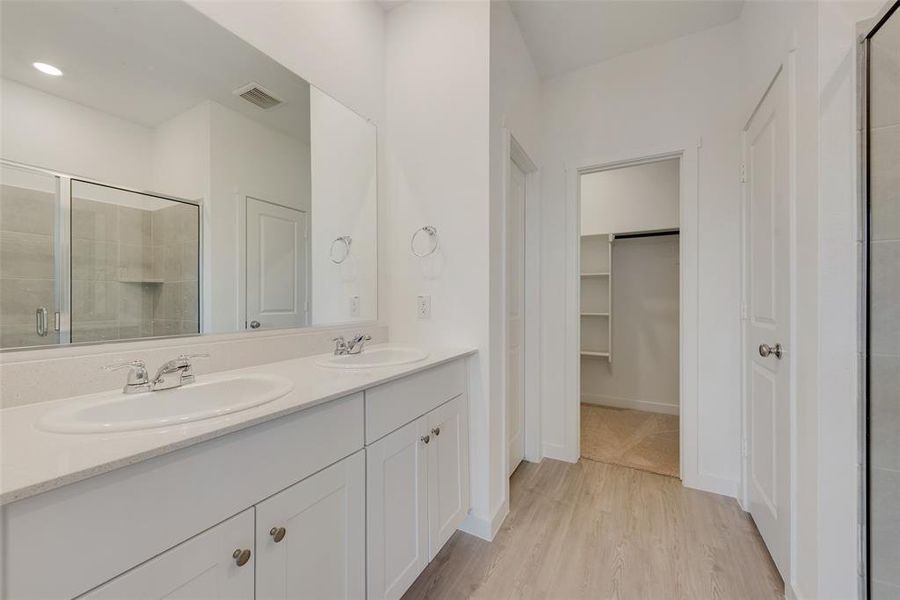 Bathroom with hardwood / wood-style flooring, vanity, and an enclosed shower