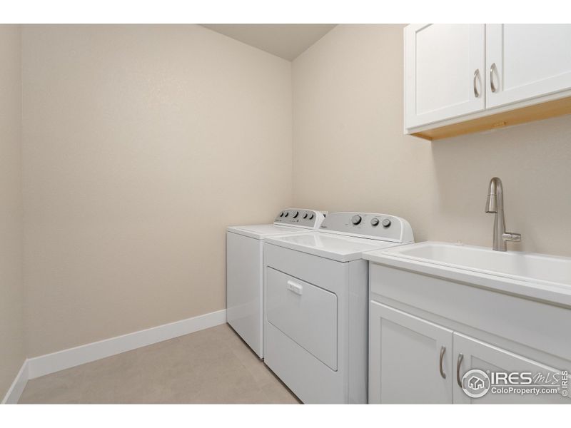 Laundry room with built in cabinets and sink