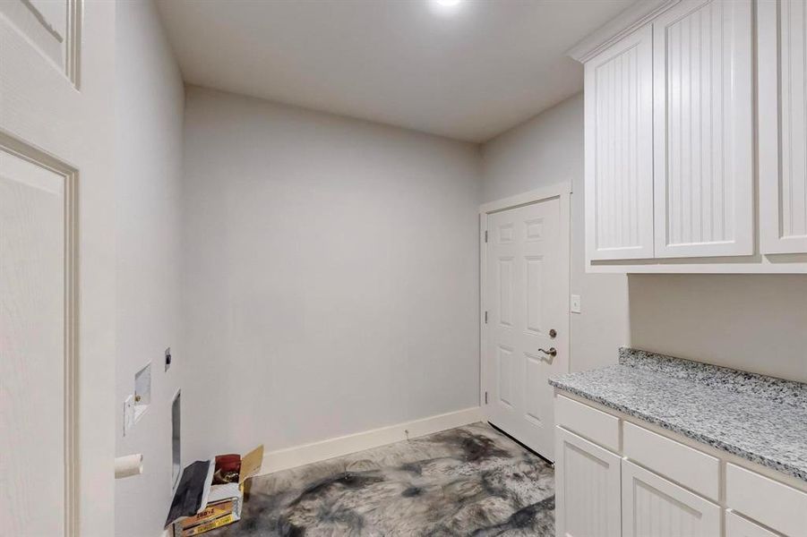 Laundry room with hookup for an electric dryer and cabinets