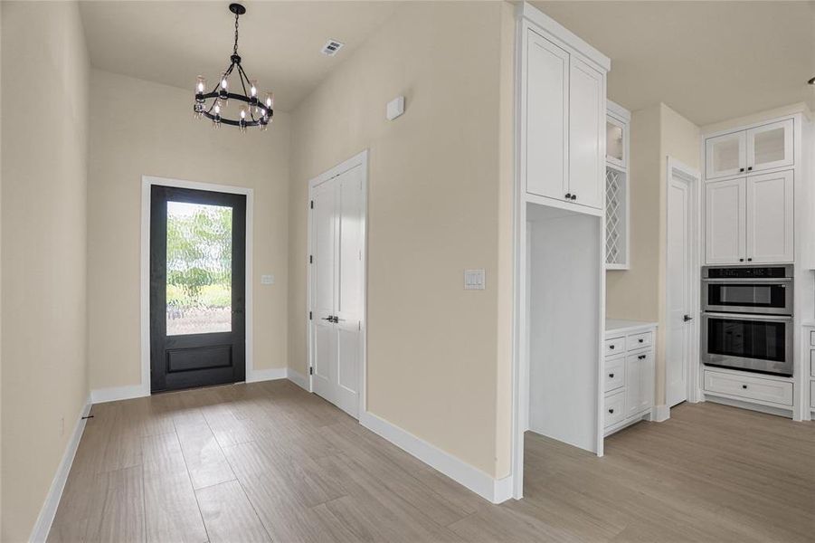 Entryway featuring a chandelier and light wood-style flooring Entryway featuring a chandelier and light wood-style flooring