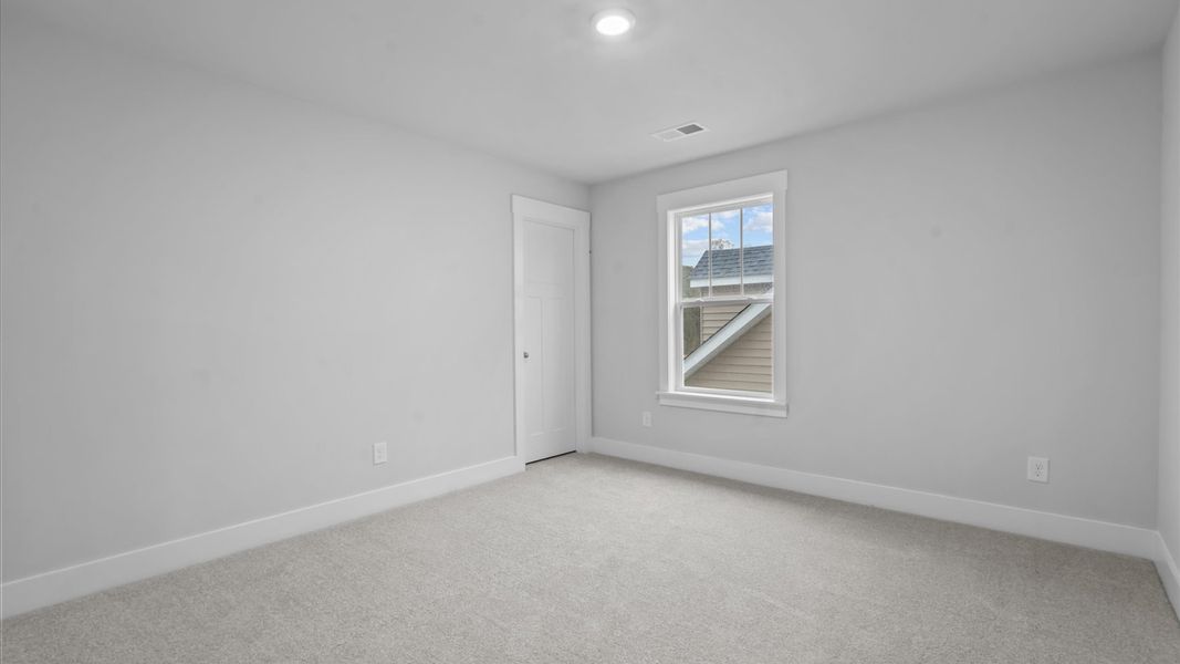 Bright and serene bedroom with comfortable carpeted flooring and large windows for vibrant light Bright and serene bedroom with comfortable carpeted flooring and large windows for vibrant light