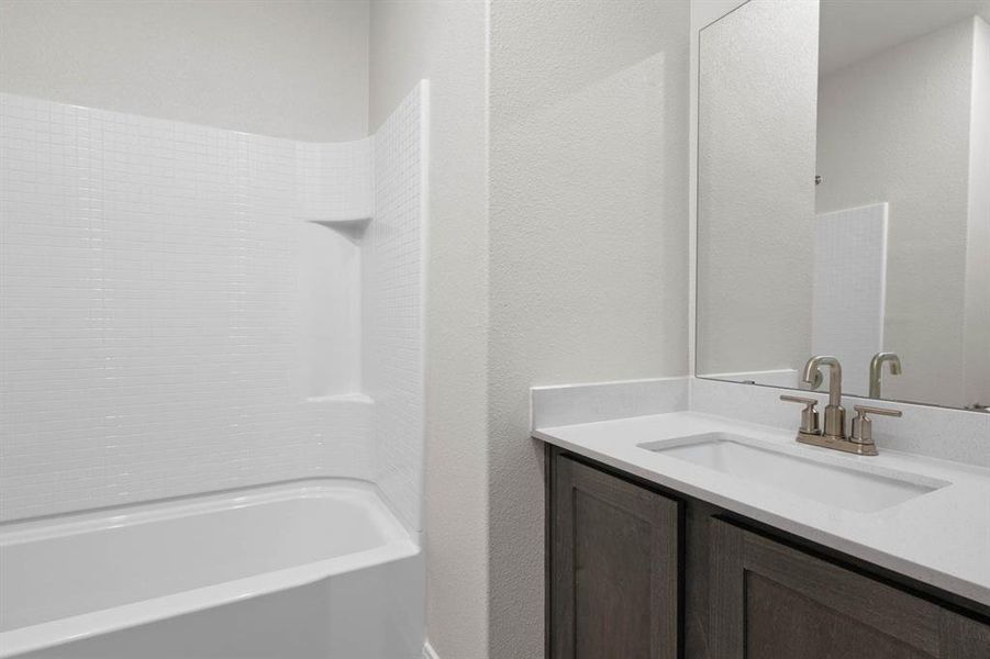 Bathroom with vanity,  shower combination, and a textured wall