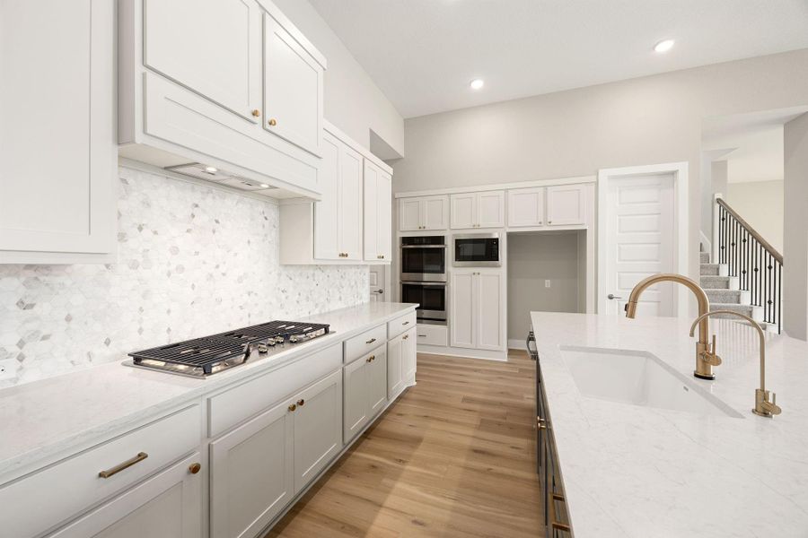 This kitchen offers a gas cooktop, double wall ovens, built-in microwave, and designer brass fixtures throughout. This kitchen offers a gas cooktop, double wall ovens, built-in microwave, and designer brass fixtures throughout.