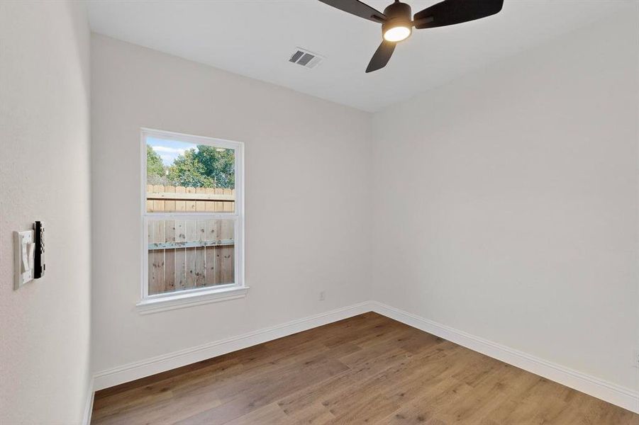 Empty room featuring wood finished floors and a ceiling fan