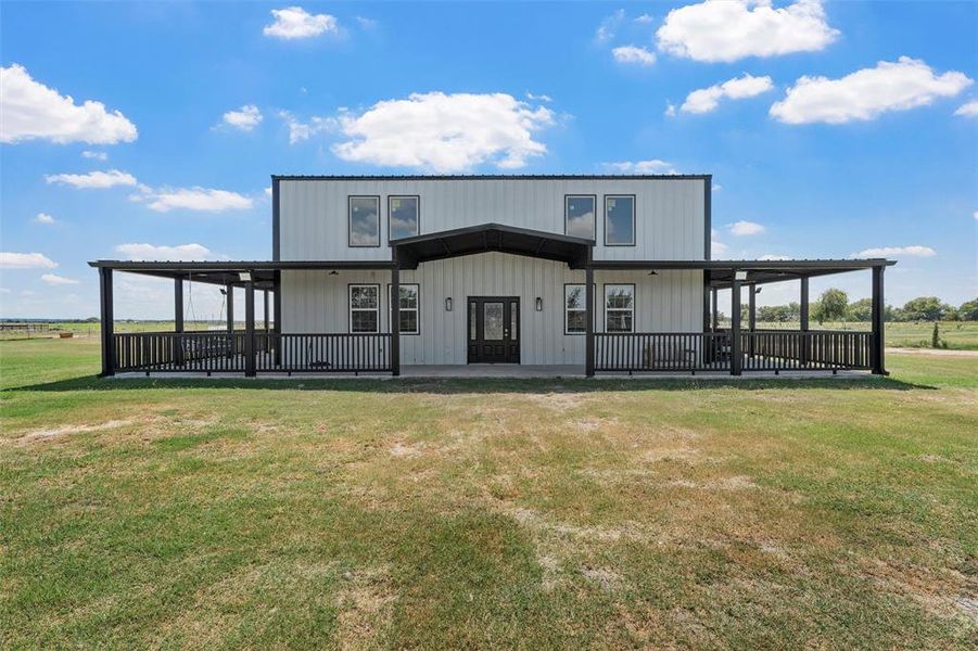 Back of property featuring a lawn and covered porch Back of property featuring a lawn and covered porch