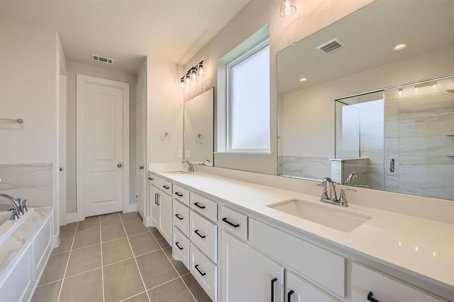 Full bath featuring a garden tub, double vanity, a shower stall, tile patterned flooring, and recessed lighting
