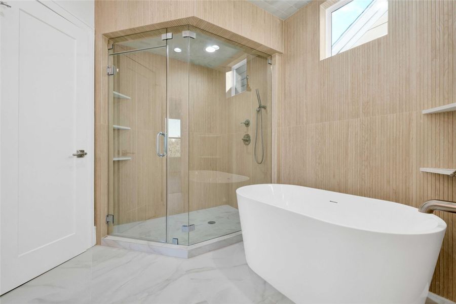 A beautifully designed primary bathroom with custom-built vanities, premium tilework, and a modern freestanding soaking tub.