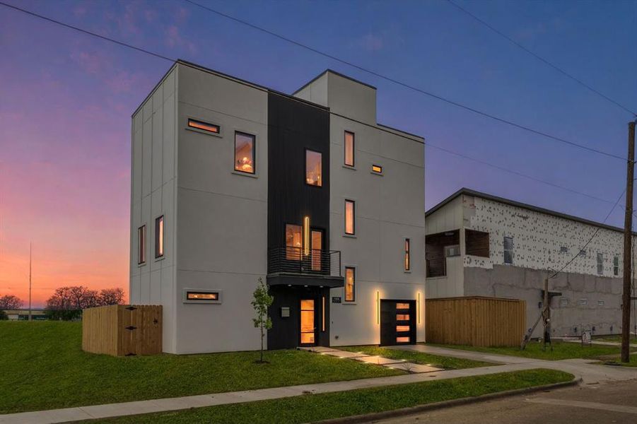 Contemporary home with concrete driveway, an attached garage, a balcony, and stucco siding